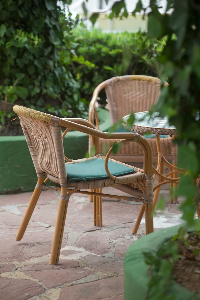 Wicker chairs in a serene outdoor garden area. Perfect for relaxation and leisure.
